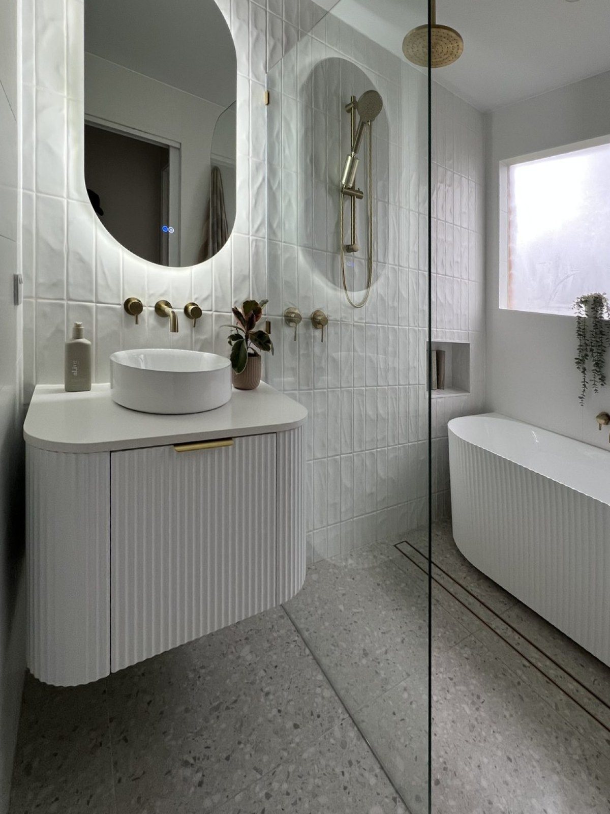 Finished vanity with oval mirror and wall mounted tapware