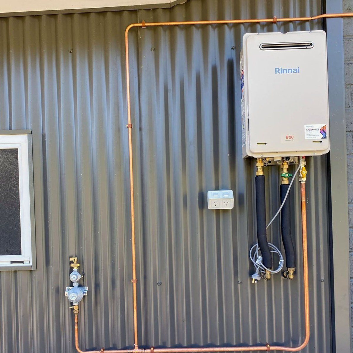 Rinnai continuous flow hot water unit on a corrugated wall with copper gas line and isolation valves