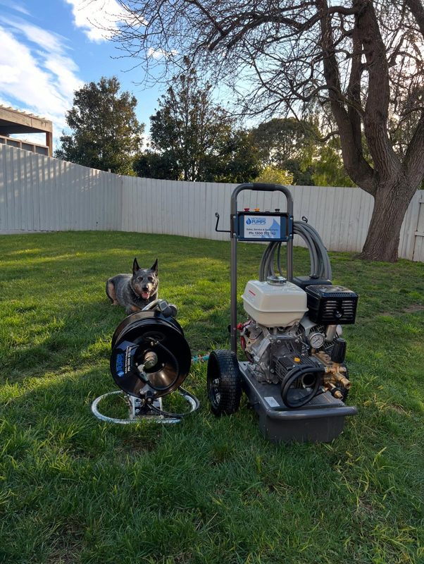 Petrol high pressure drain jetter and hose reel set up on a back lawn
